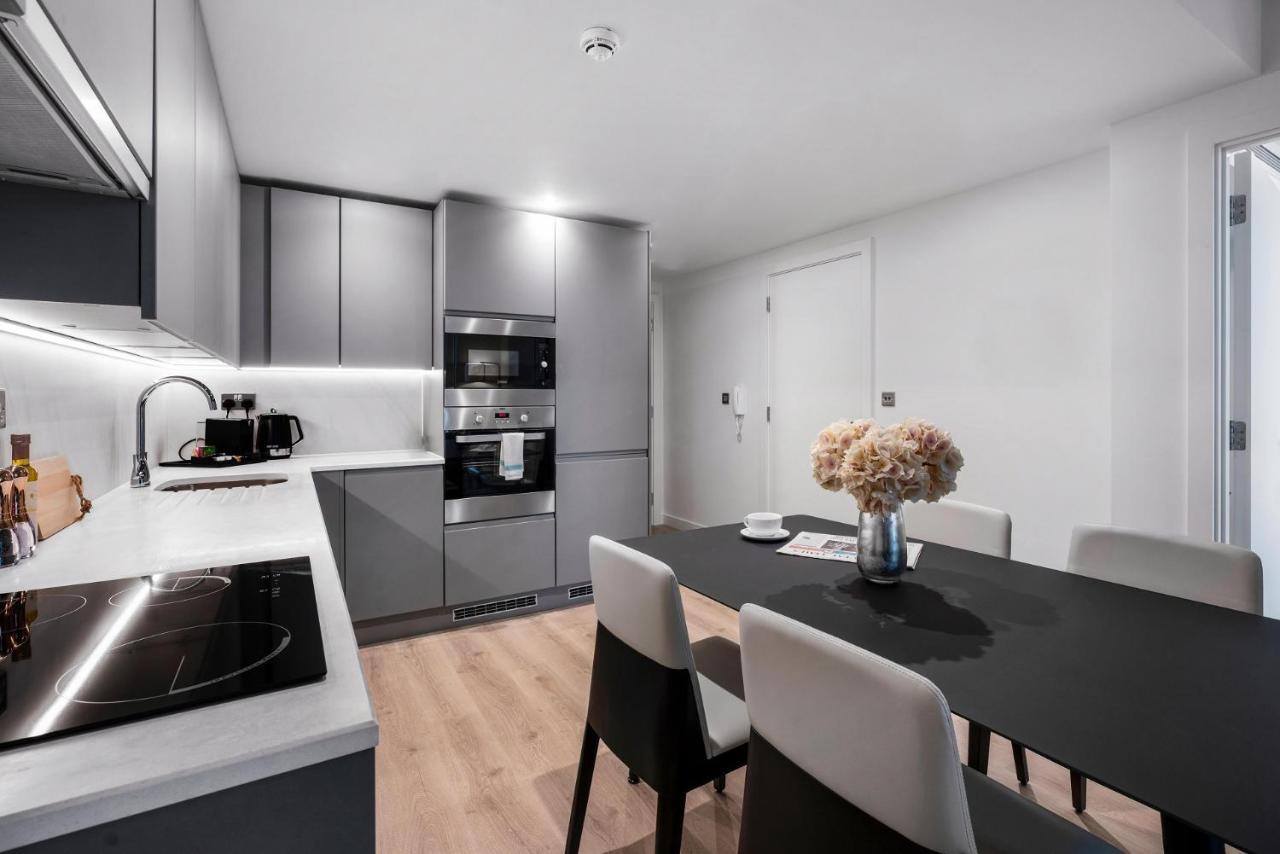 Citysuites 2 Aparthotel Mánchester Exterior foto The photo shows a modern kitchen and dining area. The kitchen features sleek gray cabinets, a countertop with an embedded cooktop, and built-in appliances, including an oven and microwave. There’s a small coffee maker on the counter. Adjacent to the 